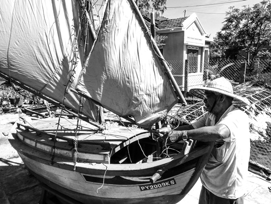 Lão ngư dân Lương Thững với những chiếc ghe bầu, tàu câu cá ngừ đại dương mô hình trong nhà mình.